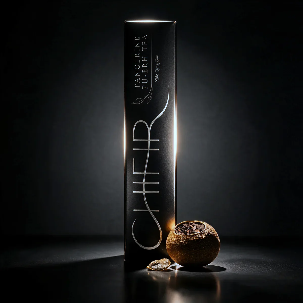 The black Tangerine Pu-erh carton with one dried tangerine piece.